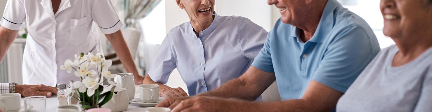 des personnes âgées en train de déjeuner ensemble, souriants