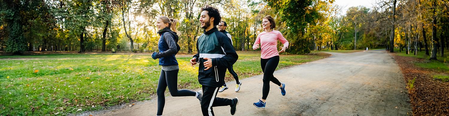un groupe d’hommes et femmes font de la course à pied dans un parc
