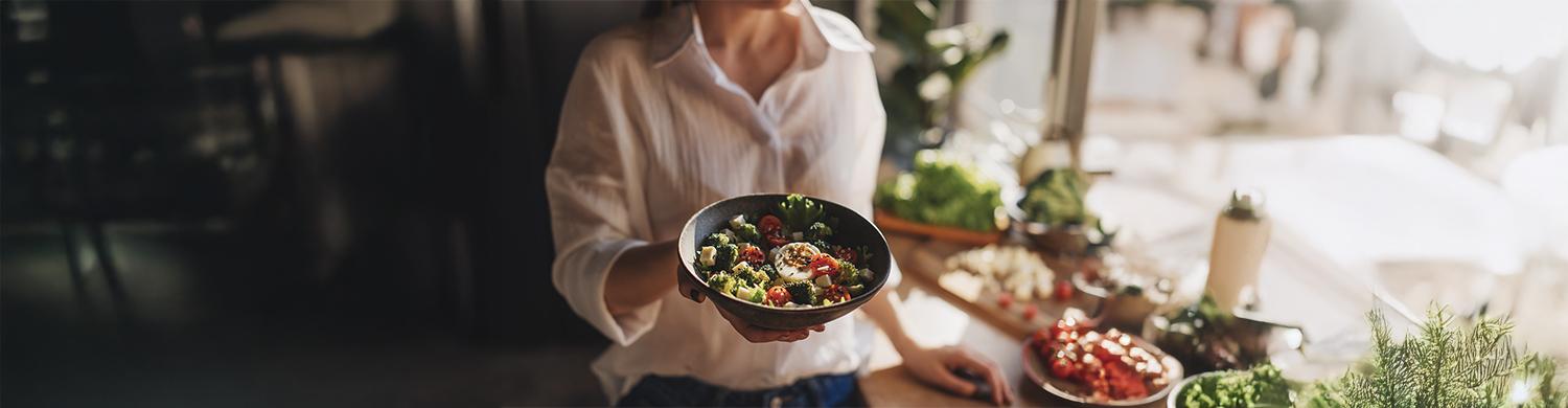 femme tend une assiette de salade équilibrée