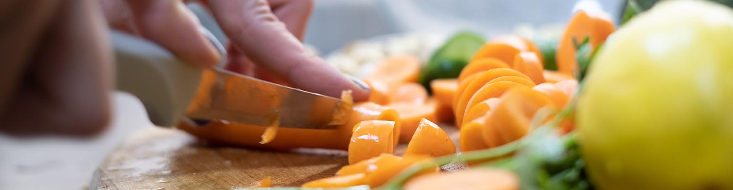 Trancher des fruits avec un couteau sur une planche de cuissine