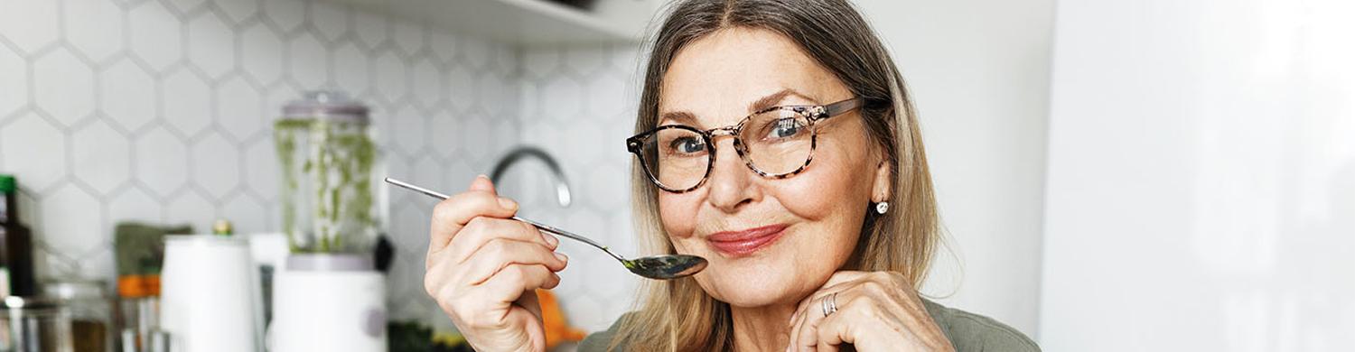 femme âgée en train de manger des fruits et légumes