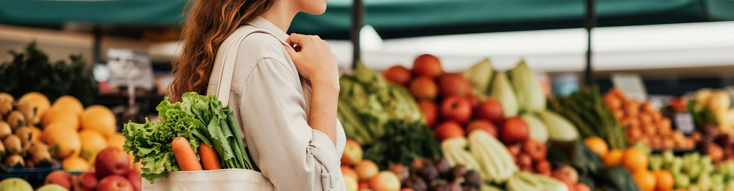 femme dans un rayon de fruits et légumes avec un sac de course à la main
