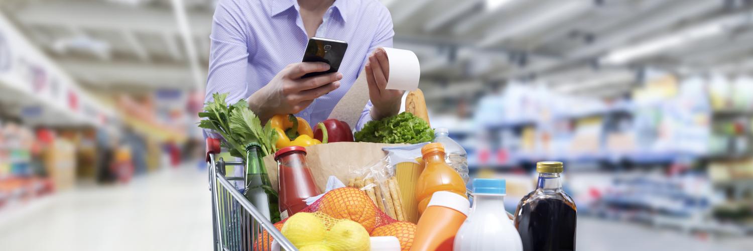 Une personne pousse un caddie dans un supermarché