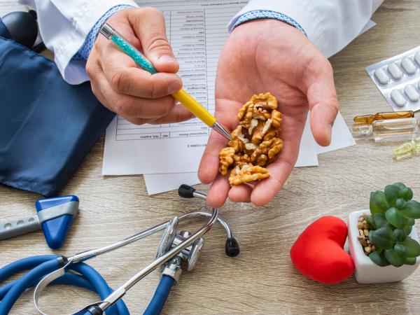 Un médecin tient des noix dans le creux de sa main