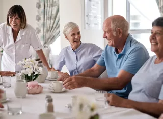 des personnes âgées en train de déjeuner ensemble, souriants