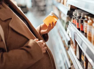 une femme enceinte choisit du miel dans un magasin
