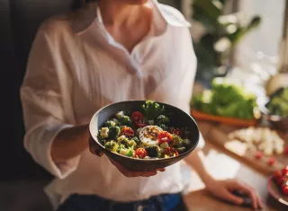 femme tend une assiette de salade équilibrée