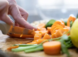 Trancher des fruits avec un couteau sur une planche de cuissine