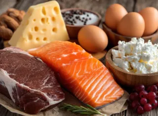 plateau de d’aliments contenant des protéines dont de la viande, du poisson, du fromage 