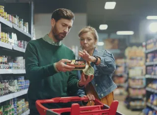 Deux personnes lisent attentivement l’étiquette d’un produit.